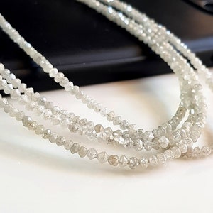 May include: A strand of white rough diamond beads. The beads are small and have a natural, unpolished look.