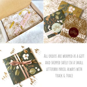May include: A gift-wrapped parcel in a white box featuring gold floral tissue paper, a pink tag with the text with love, and a white thank you sticker. Other packages are wrapped in dark green botanical paper with ribbons and stickers.