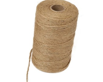 May include: A roll of natural brown twine, made from jute fiber, is wrapped around a cardboard spool. The twine is used for crafts, packaging, and gardening.