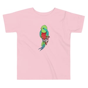 May include: A pink toddler t-shirt featuring a colourful cartoon illustration of a Quetzal bird on a branch.