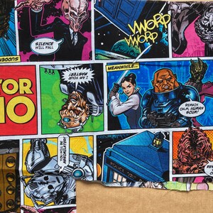 Könnte beinhalten: Ein farbenfroher Stoff mit einem Comic-Muster, das Figuren aus der Fernsehserie Doctor Who zeigt. Der Stoff enthält Bilder der Daleks, des Meisters und der Weeping Angels. Der Text auf dem Stoff enthält die Wörter "Stille wird fallen", "Du wirst assimiliert", "Meister! Ich bin dein", "Inzwischen...", "Bleib ruhig, Menschenschrott!" und "Worp Worp".