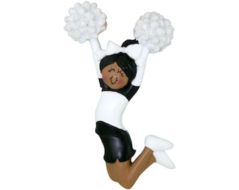 May include: A figurine of a cheerleader in a black and white uniform, jumping with pom-poms held high. The cheerleader has brown skin, black hair, and white shoes. The pom-poms are white and fluffy.