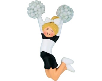 May include: A figurine of a cheerleader in a jumping pose, holding white pom-poms. The cheerleader is wearing a black and white uniform with a white bow in her hair. The figurine has a smiling face and is made of a glossy material.