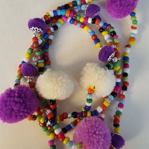Multi colour glass beaded necklace with purple and white pompoms
