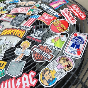 May include: A collection of colorful stickers featuring various designs and slogans related to HVAC, including "HVAC Tech", "Hangin' Ducts Daily", "High Life", "HVAC Ain't Easy", and "Bad HVAC-Tech Ass".