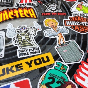 May include: A collection of colorful stickers with various designs and text, including "HVAC", "ACTECH", "CRAVE THE BRAZE", "HVAC AIN'T BAD", "DIRTY FILTERS NEVER CHANGE", "LIKE YOU", and "REFRIGERAN 22".