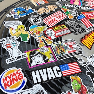 May include: A collection of colorful stickers featuring various designs, including a woman with a wrench, a cartoon character, a wasp, and a hunting license. The stickers are on a metal surface and have a variety of themes, including HVAC, "Lookin' for these?", "Big or Sma", "I Cool Them All", "Why can't my boyfriend be a HVAC Tech?", "HVAC Tech's", "Cable Tie Certified Technician", "Support Your Local HVAC Tech", "HVAC Life", "Certified HVAC Technician", "Hangin' Ducts Daily", "A Real American Hero", "HVAC King", and "This is my HVAC", among others.
