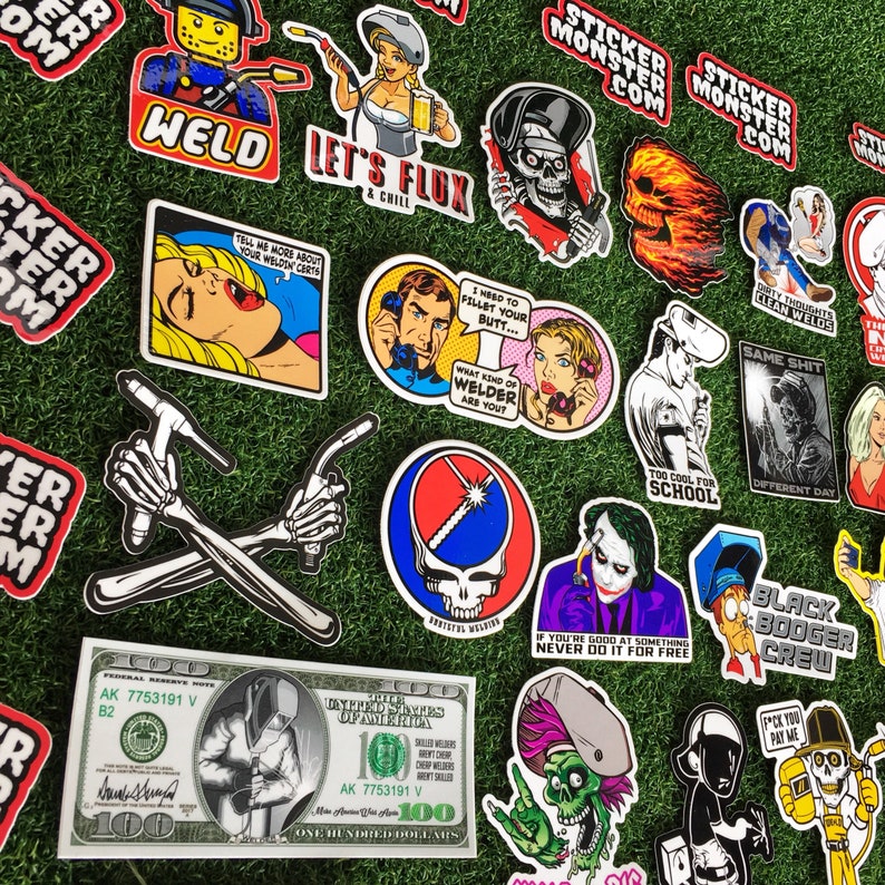 Op de afbeelding: Een verzameling kleurrijke stickers met verschillende ontwerpen, waaronder een schedel, een lasser, een cartoonfiguur en een afbeelding van een band. De stickers bevinden zich op een groene achtergrond en bevatten tekst zoals "Sticker Monster", "Weld", "Let's Flux", "Too Cool for School" en "Same Shit Different Day".