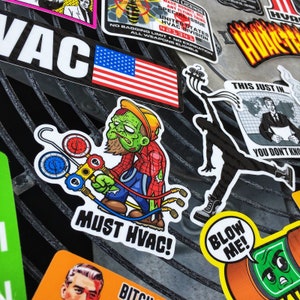 May include: A collection of stickers featuring a zombie-like character holding a set of gauges, a silhouette of a person jumping, a news report with the text "This Just In... You Don't Know", and a sticker with the text "Must HVAC!" and "Blow Me!"