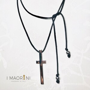 Necklace with silver cross pendant and black cord