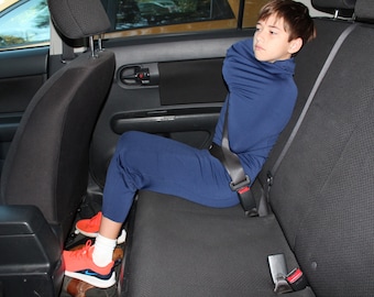 May include: A dark blue long-sleeved shirt and matching trousers set worn with white socks and bright orange athletic trainers with blue accents. The clothing is a solid dark blue colour with a high neckline and fitted sleeves and trouser legs.