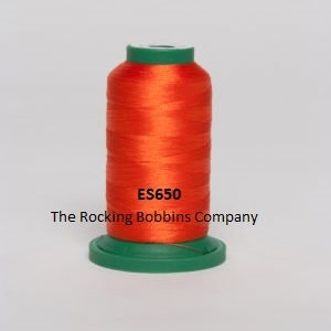 May include: A spool of bright orange thread with a green top and bottom. The spool is labeled "ES650 The Rocking Bobbins Company."