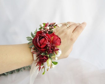 Weißes und rotes Blumenarmband. Burgunderrote Braut-Handgelenkkorsage. Rotes Bräutigam-Knopfloch. Brautjungferngeschenk. Rote Ansteckblume für den Bräutigam