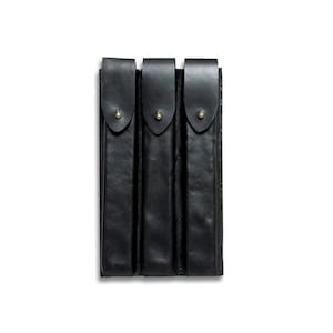 May include: Four black leather pouches with brass snaps, arranged vertically in a row.