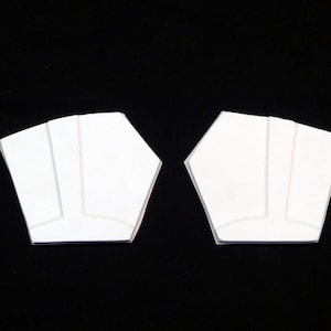 May include: Two white foam pieces shaped like a five-pointed star with a rounded edge. The pieces are symmetrical and have a raised line down the center.