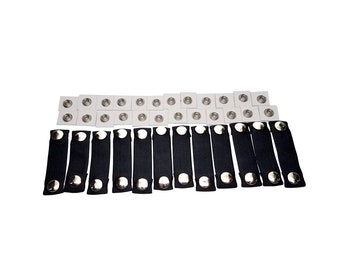 May include: A set of black elastic straps with silver metal snaps. There are 15 straps and 30 snaps in total.
