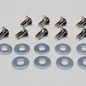 Puede incluir: Un juego de remaches y arandelas de metal plateados. Hay ocho remaches y doce arandelas.