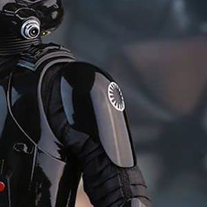 May include: A black and silver pilot suit with a circular emblem on the shoulder.