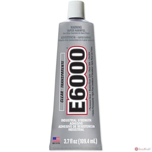 May include: A silver tube of E6000 industrial strength adhesive with a white cap. The tube is labeled "Clear - Transparent" and "Industrial Strength Adhesive". The tube contains 3.7 fl oz (109.4 mL) of adhesive.