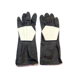 May include: A pair of black gloves with silver accents on the knuckles. The gloves are made of a soft, flexible material and have a textured surface.