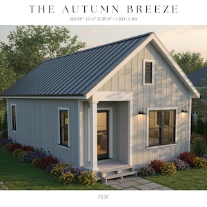 May include: A digital rendering of a small house with the text "THE AUTUMN BREEZE" at the top. The house has a gray exterior, a dark gray metal roof, and black-framed windows. Colorful flowers line the front of the house.
