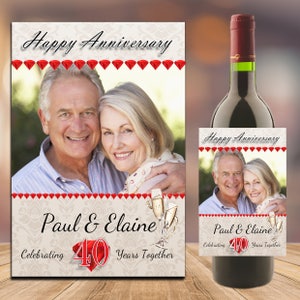 May include: A wine bottle label featuring a photograph of an older couple, the text "Happy Anniversary", "Paul & Elaine", "Celebrating 40 Years Together", and red diamond accents.