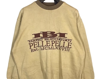 May include: A beige sweatshirt with a brown and red logo that reads "Marc Buchanan Pelle Pelle Est. MCMLXXVIII".