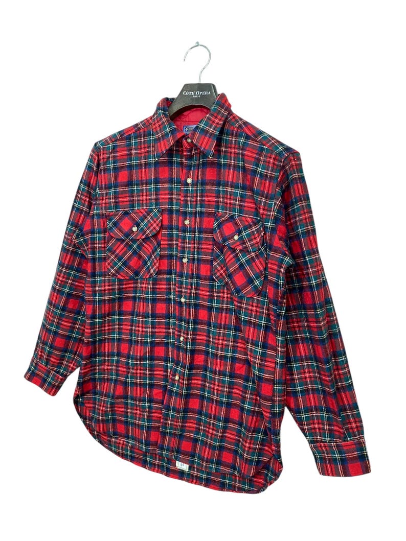 Puede incluir: Camisa de franela a cuadros rojos y verdes con mangas largas y cierre de botones.