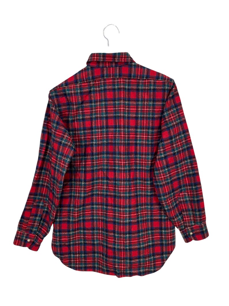 Puede incluir: Camisa de franela a cuadros rojos y verdes con mangas largas y cuello abotonado.