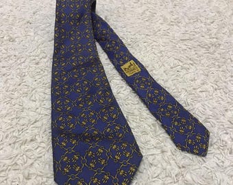 Corbata de seda vintage Hermès con estampado geométrico azul y dorado, diseño de lujo.