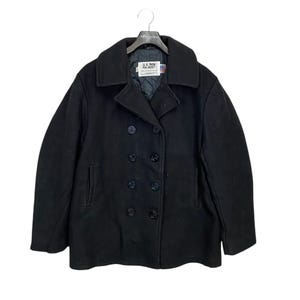 May include: A black peacoat with a double breasted closure and six black buttons. The coat has a label that reads "U.S. Navy Pea Jacket".