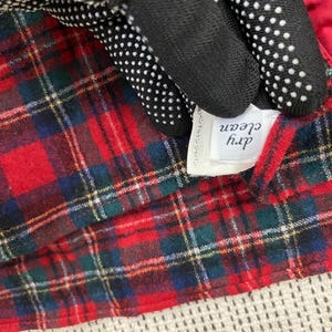 Puede incluir: Tela de cuadros rojos y negros con una etiqueta blanca que dice "dry clean" en texto negro. La etiqueta tambi&eacute;n tiene texto japon&eacute;s.