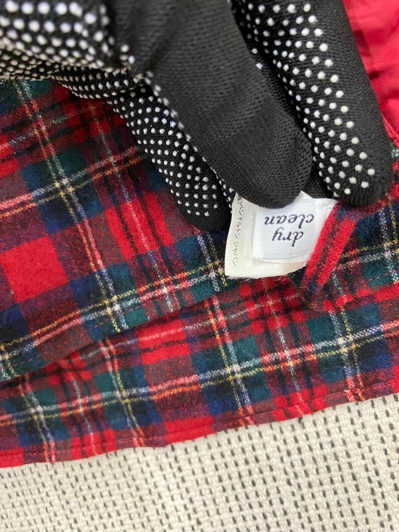 Puede incluir: Tela de cuadros rojos y negros con una etiqueta blanca que dice "dry clean" en texto negro. La etiqueta tambi&eacute;n tiene texto japon&eacute;s.