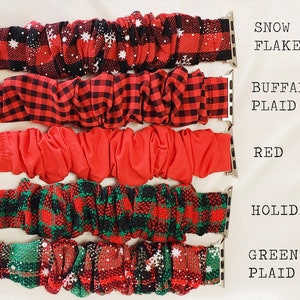May include: Five different Apple Watch bands in various holiday-themed patterns. The bands are red and green plaid, red with white snowflakes, red and black buffalo plaid, solid red, and green and red plaid with white snowflakes. The bands are labeled "Snow Flake", "Buffalo Plaid", "Red", "Holiday", and "Green Plaid".