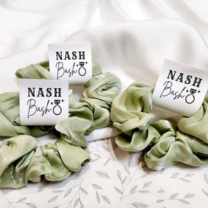 May include: Three green satin scrunchies with a white tag that says "Nash Bash" with a diamond ring symbol.