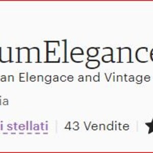 Op de afbeelding: Een kleine, sierlijke houten doos met een rood fluwelen interieur. De doos is open en het deksel is opengeklapt. De doos is versierd met gouden verf en ingewikkelde houtsnijwerk. De doos is gelabeld met "Delirium Elegance" en de tekst "Not only Italian Elegance and Vintage" staat onder het label. De tekst "Palermo, Italia" staat onder de tekst over Italiaanse elegantie en vintage. De tekst "Venditori stellati 43 Vendite" staat onder de tekst "Palermo, Italia". Vijf zwarte sterren staan rechts van de tekst "43 Vendite".