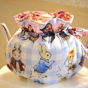 TEA COSY Standard Size fits a 32-36 Oz teapot is made with Beatrix Potter Characters Cotton check lined with pink and blue floral cotton.