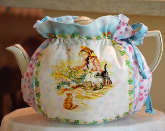 Funda para tetera de tamaño estándar Tasha Tudor Drop In Snuggie que se adapta a teteras de 32 a 36 onzas, forrada con tela de algodón estampada en color azul huevo de petirrojo.