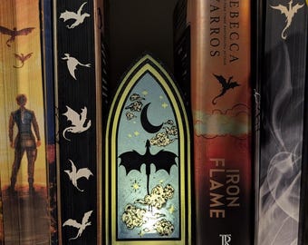 May include: A decorative, arched light-up panel featuring a dragon silhouette against a night sky with a crescent moon and stars. The panel is flanked by books with dragon and fantasy themes, creating a cohesive display.
