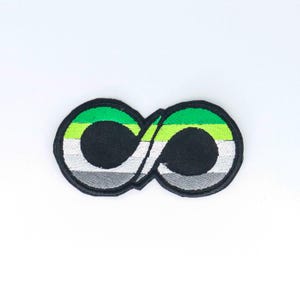 May include: Green, yellow, white, and gray infinity symbol embroidered patch. The patch is black with a white outline.