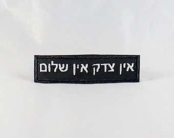 May include: Black embroidered patch with white text in Hebrew that reads "Ain Od Milvado" which translates to "There is no other besides Him".