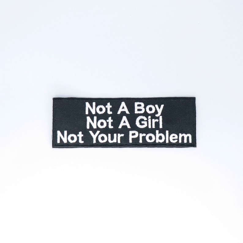 Pu&ograve; includere: Toppa ricamata nera con testo bianco che recita "Not A Boy Not A Girl Not Your Problem".