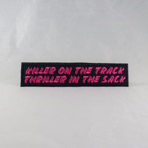 Pode incluir: Etiqueta bordada preta com letras cor-de-rosa que diz "Killer on the track thriller in the sack".