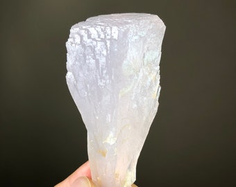 May include: A translucent, pale pink crystal with a layered, fan-shaped structure. The crystal is smooth and has a slightly iridescent sheen.
