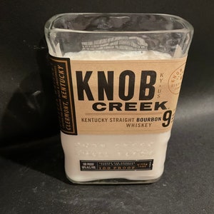 May include: A clear glass bottle with a white label that reads "Knob Creek Kentucky Straight Bourbon Whiskey 90 Proof".