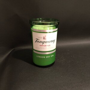 May include: A green glass candle jar with a silver label that reads "Tanqueray Imported London Dry Gin".