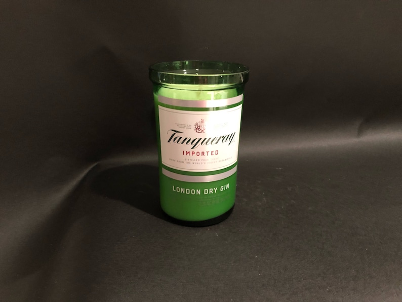 May include: A green glass candle jar with a silver label that reads "Tanqueray Imported London Dry Gin".