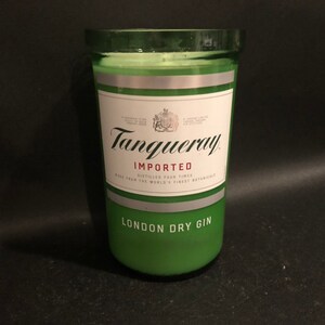 May include: A green glass candle jar with a silver label that reads "Tanqueray Imported London Dry Gin".