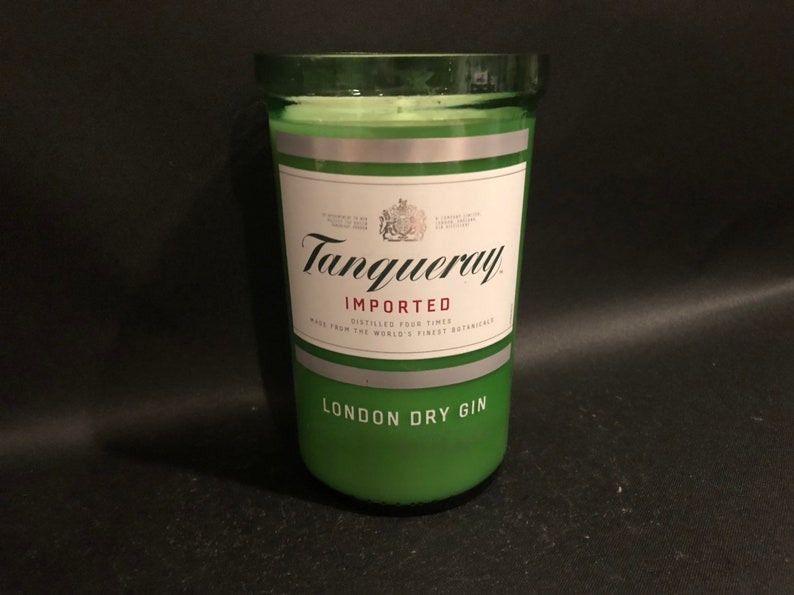 May include: A green glass candle jar with a silver label that reads "Tanqueray Imported London Dry Gin".