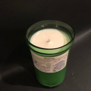 May include: A green glass candle jar with a white candle inside. The jar has a label that says "Tanqueray" and "London Dry Gin".